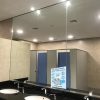 Big mirror image of toilet cubicles of an Men washroom and wash
